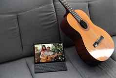 声吉他数字平板电脑沙发上舒适的首页背景在线音乐教训学习玩写作歌曲爱好概念