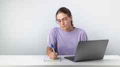 女孩坐在移动PC使笔记笔记本研究工作