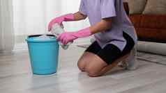 女人橡胶手套挤压破布桶洗地板上