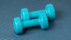 蓝色的哑铃锻炼席体育背景