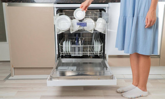 女人的手需要清洁碟子洗碗机