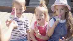 可爱的孩子们享受美味的冰奶油锥孩子吃西瓜冰棒孩子们兄弟姐妹零食糖果首页花园夏天假期热天气阳光明媚的一天童年食物糖果