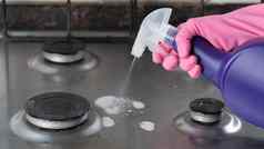 手粉红色的手套喷雾洗涤剂脏气体炉子清洁