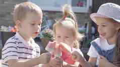 可爱的孩子们享受美味的冰奶油锥孩子吃西瓜冰棒孩子们兄弟姐妹零食糖果首页花园夏天假期热天气阳光明媚的一天童年食物糖果
