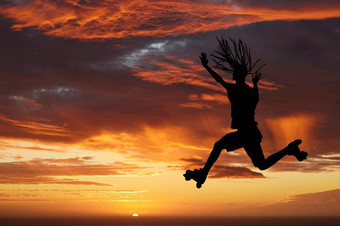 日落天空轮廓辊溜冰鞋女人跳橙色地平线享受自由旅行有趣的滑冰能源风景美自然冒险