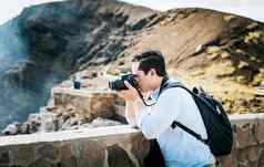 关闭旅游男人。采取照片火山的观点旅游男人。照片相机采取照片的观点喜欢冒险的男人。相机采取照片的观点