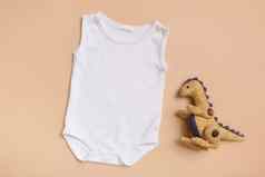 白色婴儿紧身衣裤前视图模拟标志文本设计米色背景平躺恐龙