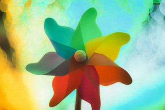 色彩斑斓的彩虹纸风车玩具金散景摘要有趣的背景