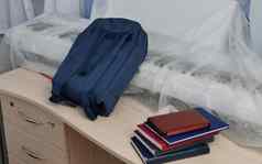 蓝色的学校背包教科书笔记本电脑学生的桌子上