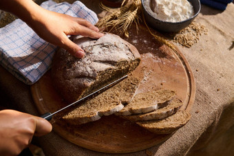 视图手切割自制的粮食轮面包健康的酵母黑麦面包木董事会