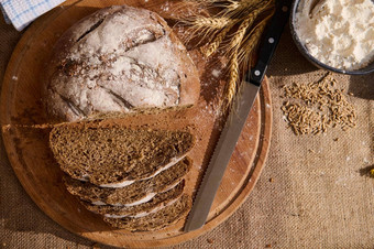 前视图新鲜的<strong>面包面包</strong>屑木董事会小穗小麦分散麦片谷物粗麻布桌布