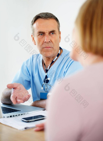 高级医生移动PC桌子上咨询女病人肖像高级医生移动PC桌子上咨询女病人诊所