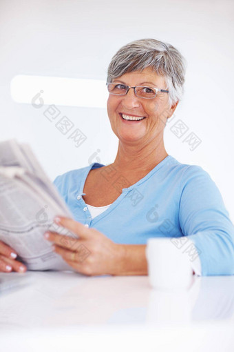 报纸早....杯微笑成熟的女人阅读报纸享受早....杯咖啡