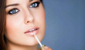 美化妆护肤品化妆品模型脸肖像美丽的女人应用唇光泽化妆品产品魅力化妆