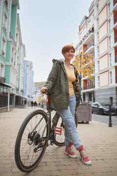 可爱的年轻的女人骑自行车城市街道