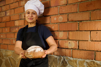 快乐女人贝克企业家持有面包面包工作手工家庭面包店商店销售自制的面包