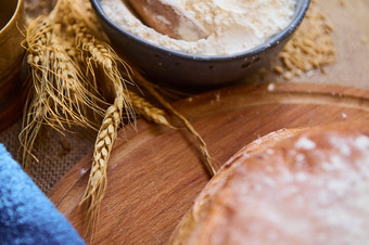 软焦点小穗小麦碗白色面粉新鲜的烤粮食面包木董事会