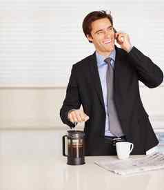 年轻的业务男人。手机准备咖啡快乐业务男人。会说话的手机准备咖啡首页