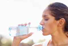 年轻的女人喝瓶装水特写镜头年轻的女人喝瓶装水