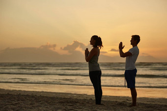 享受和平宁静自然夫妇瑜伽海滩日落