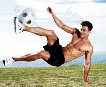 年轻的足球球员踢足球行动肖像年轻的足球球员踢足球行动天空