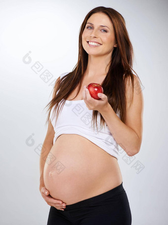 健康的选项工作室拍摄年轻的怀孕了女人持有红色的<strong>苹果灰色</strong>的背景