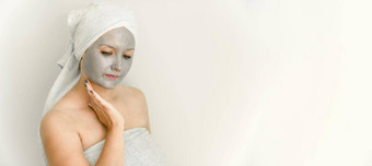 年轻的女人粘土化妆品面具触摸脸手加沙导演向下面部皮肤护理化妆品治疗
