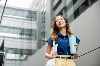 业务女人自信微笑布袋持有钢热水瓶滚筒杯子水玻璃