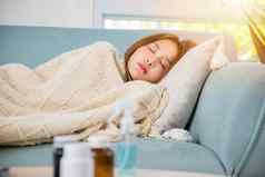 亚洲年轻的女人累了生病的睡眠休息沙发药物药片
