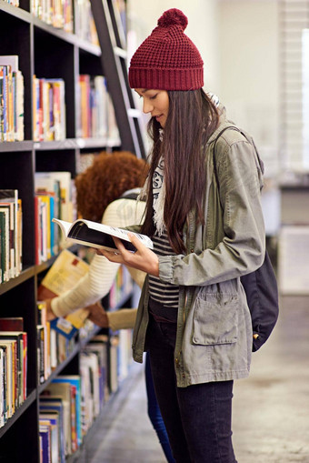 开放书开放心年轻的女人研究书站图书馆书架上