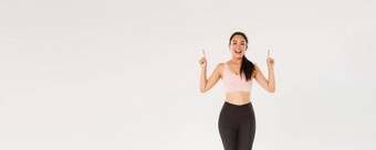 体育运动健身房健康的身体概念完整的长度快乐的微笑亚洲健身女孩女阿塞尔特运动服装显示广告指出手指邀请培训锻炼
