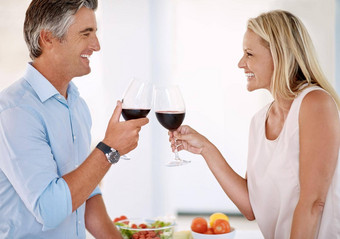 晚餐充满深情的成熟的夫妇敬酒红色的酒使晚餐