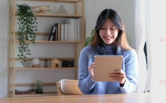 肖像微笑快乐美丽的亚洲女人放松技术平板电脑坐着表格年轻的有创意的女孩工作打字键盘首页工作首页概念