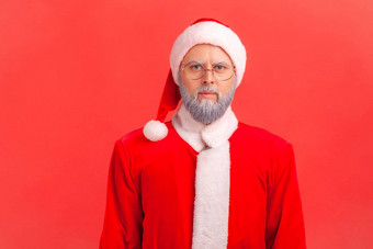 肖像上了年纪的男人。灰色的胡子穿圣诞老人老人服装相机严格的专横的面部表达式