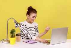 女人经理坐着工作场所显示移动PC屏幕使令人心动的手势