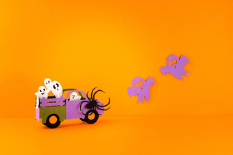 快乐万圣节假期概念万圣节手工制作的纸装饰蜘蛛鬼魂车橙色背景万圣节节日聚会，派对问候卡模型复制空间