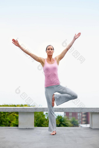 宁静平衡有吸引力的成熟的女人瑜伽在户外