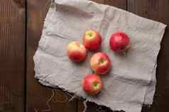 成熟的红色的苹果灰色的亚麻餐巾前视图