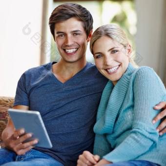 无线幸福快乐年轻的夫妇数字平板电脑沙发首页