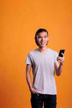 年轻的微笑亚洲男人。智能手机