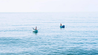 简单的背景平静黑暗蓝色的海钓鱼船白色苍白的浪花云开放限制
