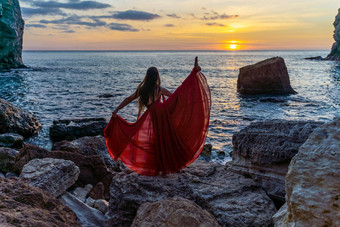 <strong>跳舞女</strong>人红色的飞行衣服海洋海海滩背景日落天空