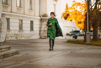 户外时尚肖像优雅的时尚浅黑肤色的女人女人模型时尚的帽绿色衣服摆姿势日落欧洲城市秋天
