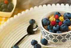 碗自制的脆皮格兰诺拉麦片酸奶新鲜的蓝莓新鲜的浆果