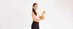 体育运动幸福活跃的生活方式概念肖像微笑健康的苗条的亚洲女孩建议吃健康的食物早餐获得能源好锻炼挤压橙色汁玻璃