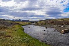 神奇的景观流动河流流岩石草冰岛