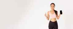体育运动技术活跃的生活方式概念满意微笑亚洲健身女孩有吸引力的女运动员显示竖起大拇指智能手机屏幕推荐移动锻炼跟踪器应用程序