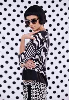 波尔卡点风格工作室拍摄retro-stylish年轻的女人黑色的白色波尔卡点背景