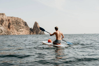 一边视图图片男人。游泳放松董事会运动型男人。海站桨董事会概念活跃的健康的生活和谐自然