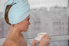 年轻的宁静放松女人水疗中心浴毛巾喝热饮料茶咖啡采取淋浴浴首页美治疗水合作用概念